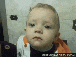 Video gif. A baby makes a deep frown with teary eyes and lowers his head. 