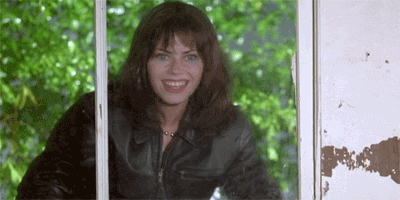 Gif of a woman holding up a sign at a window that says "want me to kill them?"
