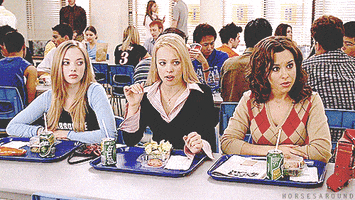 Movie gif. Amanda Seyfried as Karen, Rachel McAdams as Regina and Lacey Chabert as Gretchen from Mean Girls sit together in a cafeteria. Two of them roll their eyes and click their tongues.