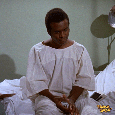 Movie gif. Terry Carter as Michael in Foxy Brown sitting on the edge of a hospital bed, wearing a patient gown, and furiously throwing balled-up cloth on the floor.