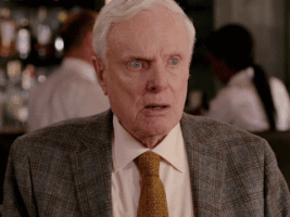 Video gif. A older man is in a restaurant and he leans back, shocked, wide eyed, and a little bit scared as he asks, "How do you know about that?"