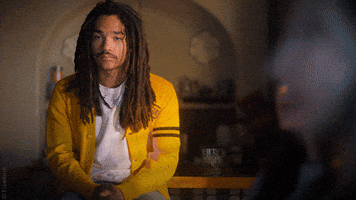 TV gif. Luka Sabbat as Luca from Grownish sits wearing a yellow cardigan. He speaks casually offscreen, punctuating his words with a slight toss of his hands, then glances to the side. Text, "All facts."