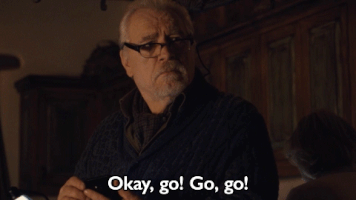TV gif. Brian Cox as Logan Roy from Succession gestures at someone with his finger to hurry up. Text, "okay, go! Go, go!"