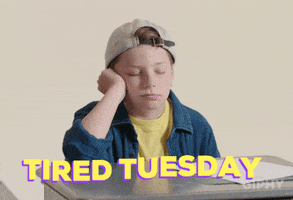 Video gif. A boy rests his elbow on a desk and his cheek on his fist as he starts to doze before startling awake again. Text, "Tired Tuesday."