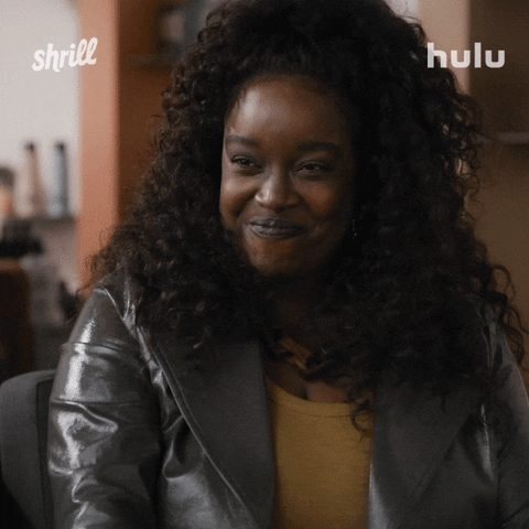TV gif. Lolly Adefope as Fran on Shrill cutely laughs and giggles, moving her shoulders up as if she’s a little shy