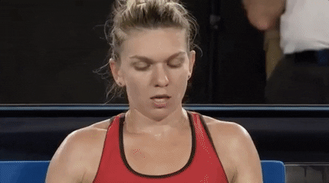 a woman in a red tank top is sitting in a chair with her eyes closed .