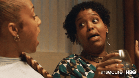 TV gif. Natasha Rothwell as Kelli Prenny from Insecure shares a wide-eyed laugh with a friend over wine.