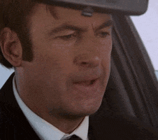 TV gif. Bob Odenkirk as Saul in Better Call Saul. He's sitting in his car and it's a close up on his face. He's breathing heavily and he suddenly scrunches his whole face and bites his lip in anger, looking like he's squeezing something very hard out of frustration.