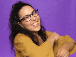 Video gif. Excited woman rolls her arms in front of her as she does a happy dance.