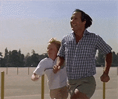 Movie gif. In a scene from National Lampoon's Vacation, Chevy Chase as Clark Griswold and Anthony Michael Hall as his son Rusty run joyously in slow motion across an empty parking lot. You can almost hear "Chariots of Fire" playing in the background.