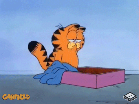 Cartoon gif. A weary Garfield the cat falls flat on his face into his bed box.