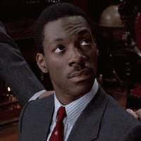 Movie gif. Eddie Murphy as Billy Ray in Trading Places, dressed in a suit, looking up and to the side and then looking straight-faced at us.