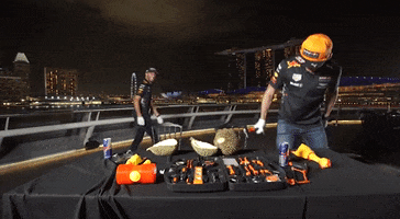 Sports gif. Racing driver Daniel Ricciardo attempts to break open a spiky durian fruit with a hammer, hitting it several times before he throws the hammer down and gives up.