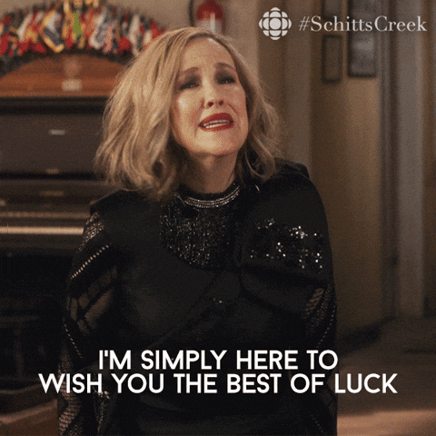 Schitt's Creek gif. Catherine O'Hara as Moira in a medium length blonde wig, says, "I'm simply here to wish you the best of luck."