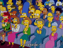The Simpsons gif. Full theater audience including Marge and Homer applaud and cheer in unison. Text, "*cheering.*"