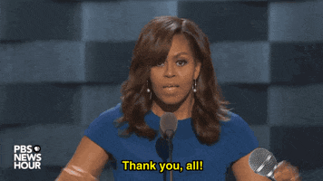 Political gif. Michelle Obama stands at a podium with an expression of gravitas. She thanks the the audience and raises her hands in closing. An animated mic drops from her hand before she blesses the crowd. Text, "Thank you all. God bless."