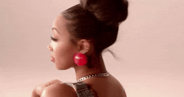 Video gif. Pretty woman looks at us over her shoulder and tosses us a wink.