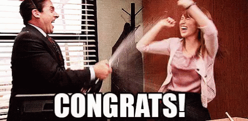 The Office gif. Steve Carell as Michael on The Office sprays a bottle of champagne over Ellie Kemper as Erin Hannon. Michael wears a goofy large party hat and shakes the bottle around for more champagne to spray out. Erin dances and waves her arms around excitedly as she’s getting sprayed. The flashing text reads, “Congrats!”