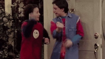 TV gif. Ben Savage as Cory Matthews and Rider Strong as Shawn Hunter from Boy Meets World pump their fists and lift their right knees in sync, smiling at each other in celebration.