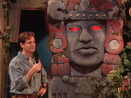Reality TV gif. Kirk Fogg on Legends of the Hidden Temple stands next to Olmec the statue. Kirk stands still, holding a mic up to his face, as Olmec says, “That is correct.”