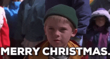 Movie gif. A smiling Jake Lloyd as Jamie in Jingle All the Way holds up an ornament and says, “Merry Christmas.”