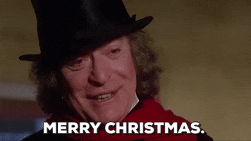 Movie gif. Michael Caine as Ebenezer Scrooge in A Muppet Christmas Carol has had his change of heart, and wishes us a "Merry Christmas."