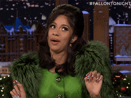 Celebrity gif. Rapper Cardi B on the Tonight Show side eyes Jimmy Fallon who is off screen. She nods her head as she says, “okurrr," and then purses her lips together as if holding in a laugh.