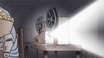 Illustrated gif. A man walks up and sits next to a projector while holding a bag of popcorn. He says, "This should be good."
