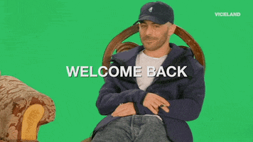 Celebrity gif. Musician The Alchemist sits slouched in front of a greenscreen, a smug smirk playing upon his face. Text grows in size, saying, "Welcome Back."