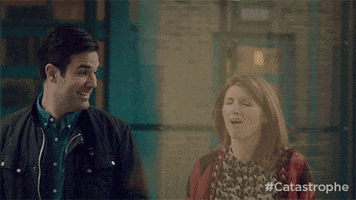 TV gif. Sharon Horgan as Sharon Morris and Rob Delaney as Rob Norris on Catastrophe walk down the street laughing. Sharon holds her hand up and Rob high fives her like they both did a great job.