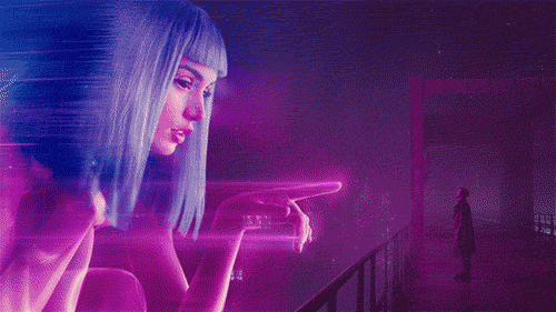 Blade Runner 2049
Joe, a robot that is tasked to find and kill robots that become sentient, falls in love with a hologram that is sold and developed by the very same large corporation that produced him and all of the other robots. Their love seem genuine, but you can't help but ask yourself if it was all programmed. His name was actually given to him by his hologram girlfriend. She dies later on, but he meets her again in the form of an giant advertisement. She stops and calls him Joe.

That's just one of the many rabbit holes in this movie. You start to wonder what exactly is the fundamental definition of sentience. Does it matter if you can't even tell the difference between a human and a robot anymore? Do robots have to be treated differently when they can feel, do, and suffer just like you?