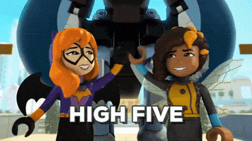 Cartoon gif. Batgirl and Bumblebee in Lego DC Superhero Girls smile and high give, then walk towards us with a robot following behind them. Text, "High five."