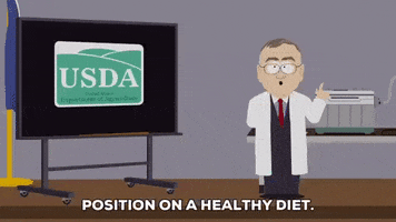 South Park gif. Scientist stands in front of a projector screen displaying a presentation that is labeled “USDA Department of Agriculture.” He says, “Position on a healthy diet. There’s been a lot of confusion about gluten lately – people,” as the display changes to a “Gluten Breakdown” chart flowchart.