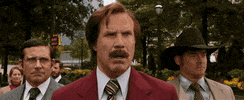 Movie gif. Will Ferrell as Ron Burgundy, Steve Carrell as Brick Tamland, and David Koecher as Champ Kind in anchorman 2 stand together. Ron says, “oh, my goodness! That’s the most badass thing I have ever heard!”