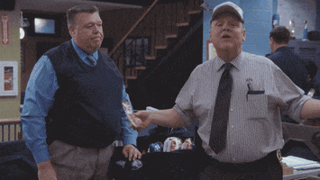 TV gif. Joel McKinnon Miller as Noel Scully on Brooklyn Nine Nine looks at us with a bored look as Dirk Blocker as Michael Hitchcock talks to us excitedly. They then high five each other and move out.