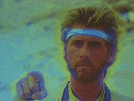 Movie gif. Barry Bostwick as Ace Hunter from Megaforce points at us, kisses his thumb, and presents it in a thumbs up.