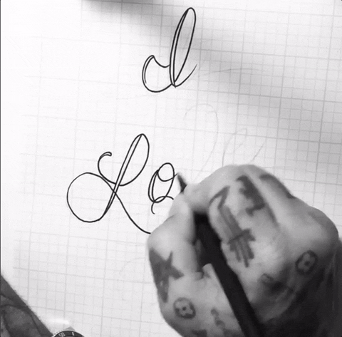 Illustrated gif. Tattooed hand sketches out very scrolly text on graph paper. Text, “I love you.”