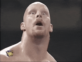 Celebrity gif. Steve Austin slams both his hands on his bald head with a look of sheer shock on his face. 
