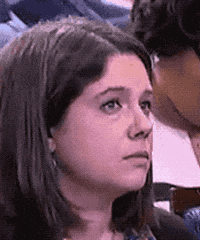 Video gif. Journalist among press gaggle giving various perplexed facial expressions, raising her eyebrows, squinting, frowning, and slightly smiling.
