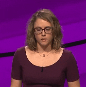 Video gif. Contestant on a game show shakes her head while hesitantly trying to figure out an answer to a question.