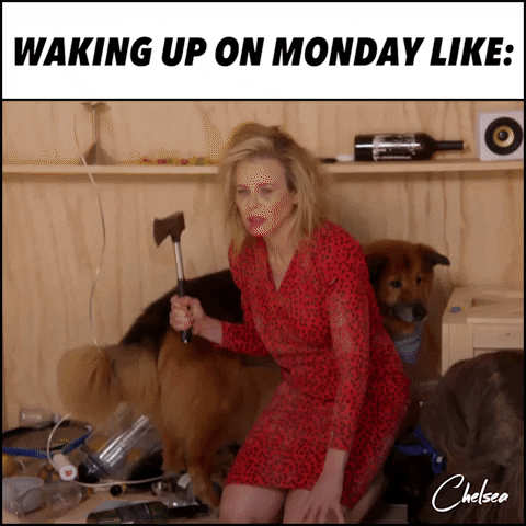 Celebrity gif. Chelsea Handler looks disheveled and hungover with smeared makeup, holding an axe and sitting in a messy room with two dogs. Text, "Waking up on Monday like."