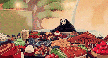 Movie gif. Cartoon no-face from Spirited Away sits in a hot spring with a lumpy body. He spreads his hands out wide in celebration. In front of him is a feast of delicious foods including dumplings, ribs, grilled fish, rice, and more, all being presented to him by a crowd of people. People on the sidelines cheer with their arms over their heads.