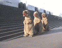 Pohyblivý obrázek se třemi tancujícími dinosaury na ulici. 
