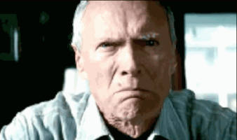 Celebrity gif. A disgruntled Clint Eastwood glares and frowns, shaking in anger.
