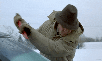 Movie gif. William H Macy as Jerry Lundegaard in Fargo vigorously scraping ice off his car window.