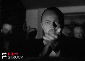 Movie gif. Orson Welles as Charles Foster Kane in Citizen Kane claps his hands slowly, tight-lipped and serious.
