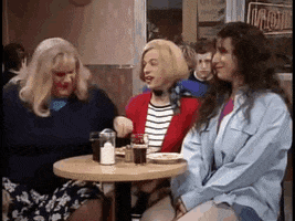 SNL gif. Chris Farley, David Spade, and Adam Sandler are dressed as women in a cafe. Out of nowhere, Farley grabs Spade by the neck and screams in his face. Sandler tries not to break character. Text at the bottom reads, "Lay off of me, I'm starving."
