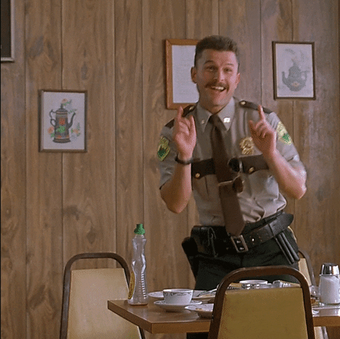 Movie gif. Steve Lemme as Mac in Super Troopers bends over in laughter as he points both fingers ahead. Text, "Ah ha ha."