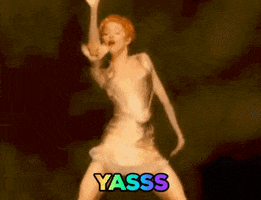 Music video gif. Madonna in the video for Fever shakes her hips and whirls her arms while wearing a metallic corset and mini skirt. Text, "Yasss."