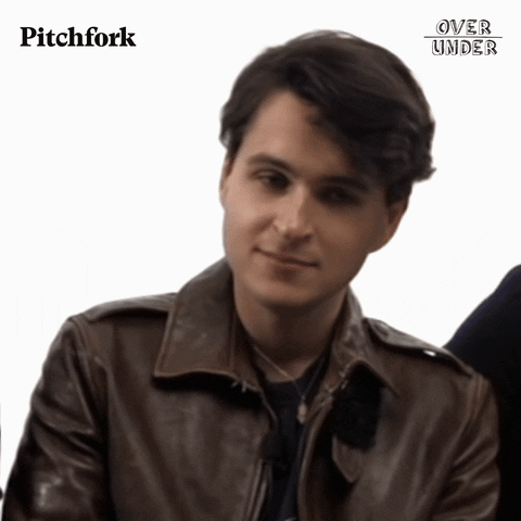 Celebrity gif. Ezra Koenig of Vampire Weekend tilts his head and rolls his eyes, but tries to keep a polite expression on his face despite being annoyed.